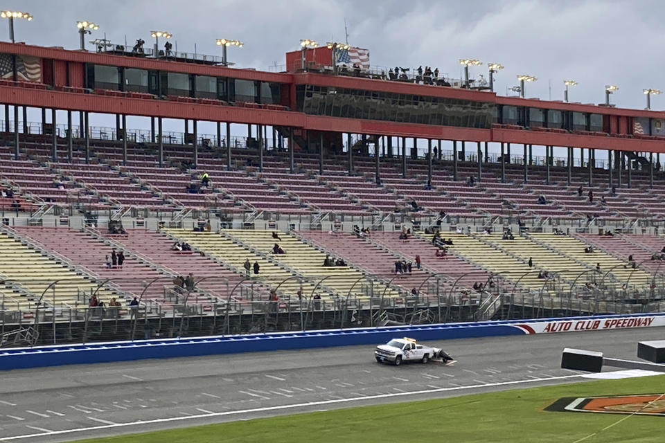 A truck dries the racetrack at Auto Club Speedway before the start of the NASCAR Xfinity Series in Fontana, Calif., Saturday, Feb. 25, 2023. NASCAR has canceled practice and qualifying sessions for the weekend races at Fontana because of ongoing heavy rains. (AP Photo/Greg Beacham)
