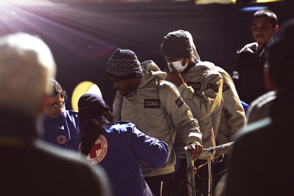 Migrants disembark from the SOS Humanity 1 humanitarian ship in the Italian southern port town of Crotone, Monday, March 4, 2023. German charity SOS Humanity said the Libyan coast guard used violence and fired live bullets as its crew rescued migrants in the Mediterranean Sea on Saturday. The charity said that several migrants aboard three unseaworthy boats had to jump into the water. It said that it rescued 77 people, but that others were forced aboard a coast guard vessel. Some family members were separated and at least one migrant drowned. (Antonino D'Urso/LaPresse via AP )