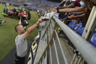 Baltimore Ravens coach John Harbaugh gives a fan his hat after practice at the NFL football team's training camp Saturday, July 31, 2021, in Baltimore. (AP Photo/Gail Burton)