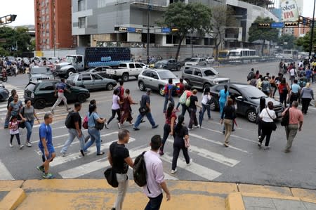 People walk on the street during a blackout in Caracas