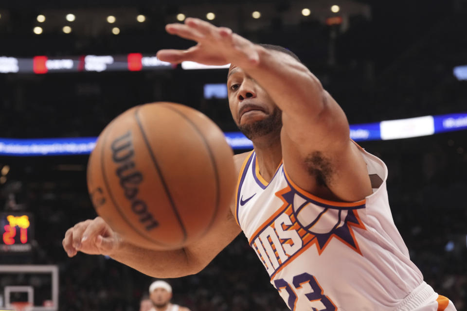 Phoenix Suns' Eric Gordon strains to retain the ball during an NBA basketball game against the Toronto Raptors in Toronto on Wednesday, Nov. 29, 2023. (Chris Young/The Canadian Press via AP)