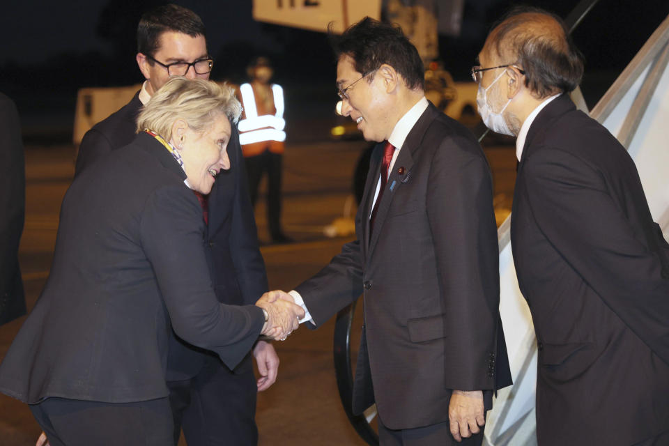 Japan's Prime Minister Fumio Kishida, second right, is met by Patrick Gorman and Allanah McTiernan, left, as he arrives in Perth to begin a 3-day-visit to Australia on Friday, Oct. 21, 2020. (Trevor Collens/Pool via AP)