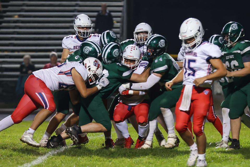Dover's Tobey Desroches (67), Coen Monahan (70) and Kyle Merrill (64) bring down a Memorial ball-carrier during Friday's Division I football game.