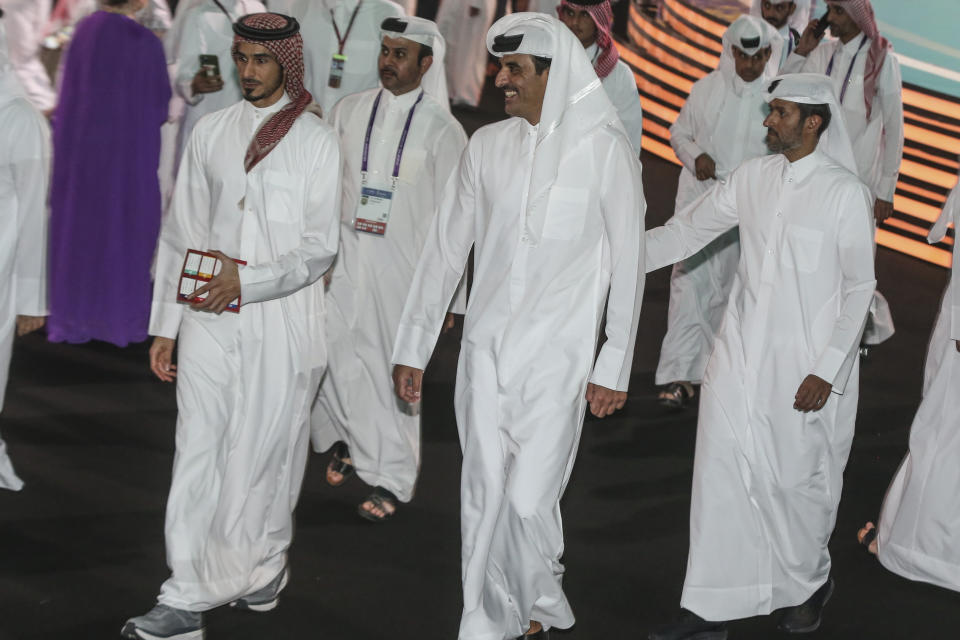 Emir of Qatar Sheikh Tamim bin Hamad Al Thani, center, smiles during the 2022 soccer World Cup draw at the Doha Exhibition and Convention Center in Doha, Qatar, April 1, 2022. A former CIA officer who spied on Qatar’s rivals to help the tiny Arab country land this year’s World Cup is now under FBI scrutiny and newly obtained documents show he offered clandestine services that went beyond soccer to try to influence U.S. policy, an Associated Press investigation found. (AP Photo/Hussein Sayed)
