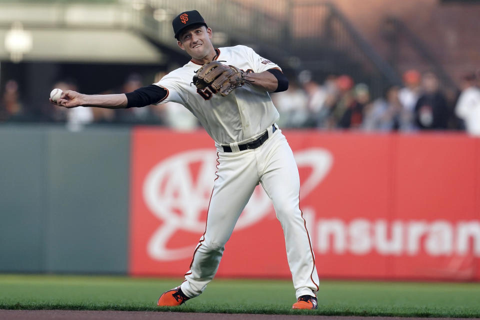 San Francisco Giants' Jason Vosler throws out Milwaukee Brewers' Kolten Wong at first base during the first inning of a baseball game in San Francisco, Monday, Aug. 30, 2021. (AP Photo/Jeff Chiu)