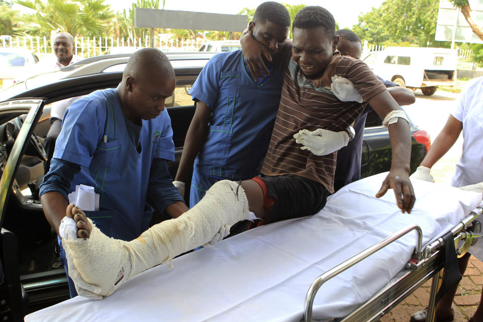 In this Thursday, Jan. 17, 2019 photo, an injured man is helped at a private hospital after an alleged assault by a group of uniformed soldiers in Harare, Zimbabwe. Zimbabwe on Friday faced a "total internet shutdown," a media group said, after a days-long violent crackdown on people protesting a dramatic fuel price increase. Badly injured people streamed into a hospital in the capital after alleged assaults by security forces. (AP Photo/Tsvangirayi Mukwazhi)