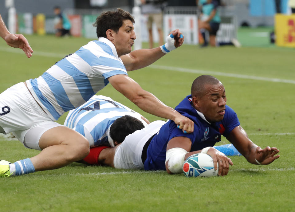 CORRECTS NAME OF SCORER : France's Gael Fickou, right, dives across the line to score a try during the Rugby World Cup Pool C game at Tokyo Stadium between France and Argentina in Tokyo, Japan, Saturday, Sept. 21, 2019. (AP Photo/Christophe Ena)