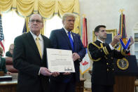 President Donald Trump prepares to award the Presidential Medal of Freedom, the highest civilian honor, to Olympic gold medalist and former University of Iowa wrestling coach Dan Gable in the Oval Office of the White House, Monday, Dec. 7, 2020, in Washington. (AP Photo/Patrick Semansky)