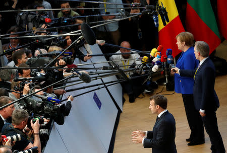 French President Emmanuel Macron and German Chancellor Angela Merkel talk to the media as they arrive at an extraordinary European Union leaders summit to discuss Brexit, in Brussels, Belgium April 10, 2019. REUTERS/Susana Vera