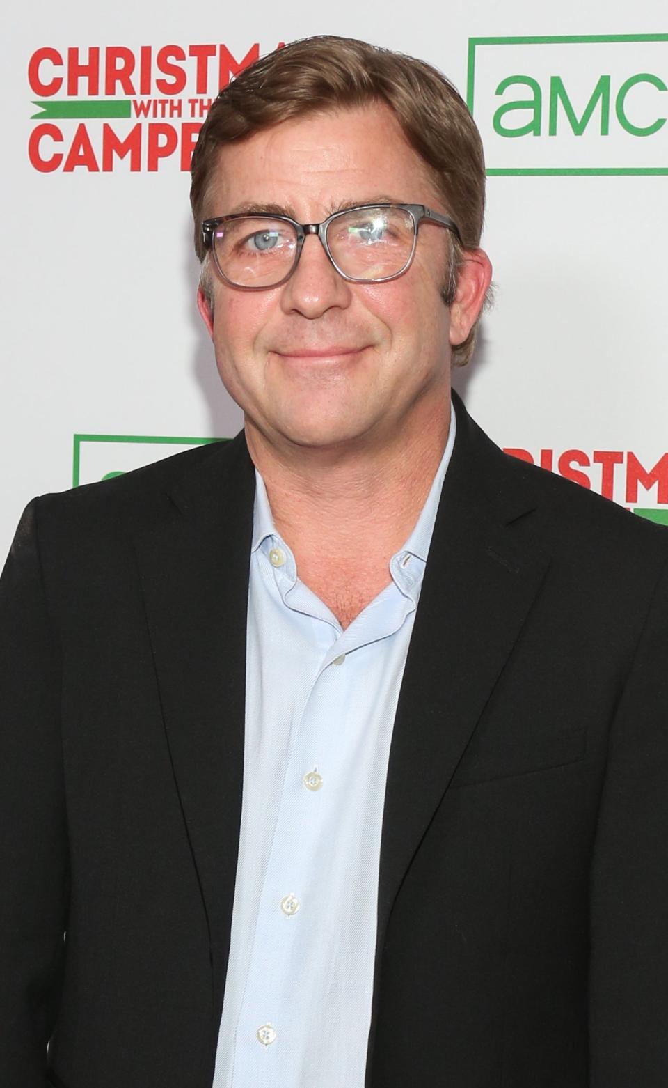 Close-up of Peter in a suit, no tie, smiling at a media event