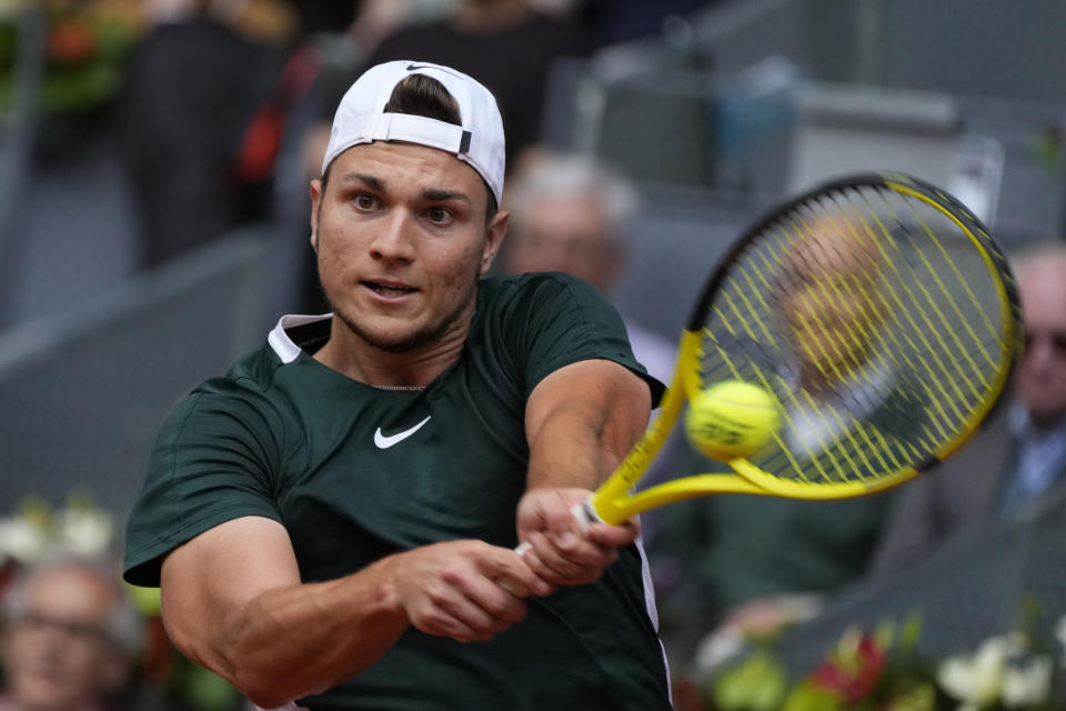 Miomir Kecmanovic of Serbia returns the ball to Rafael Nadal of Spain during their match at the Mutua Madrid Open tennis tournament in Madrid, Spain, Wednesday, May 4, 2022. (AP Photo/Paul White)