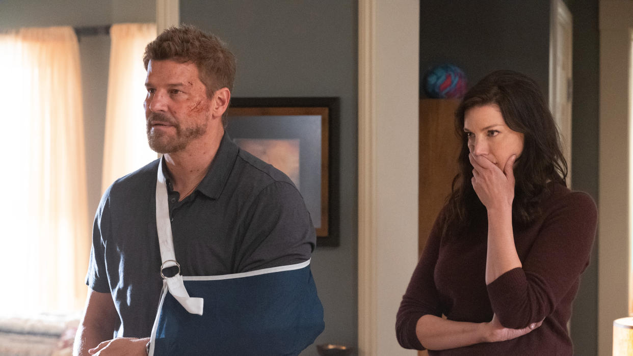  L to R: David Boreanaz as Jason Hayes, with a bruised face, wearing an arm brace, with Jessica Paré as Mandy Ellis, looking concerned in SEAL TEAM season 6 episode 1 “Low-Impact” 