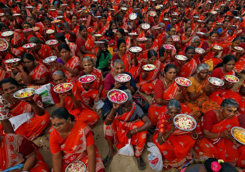 Women hold plates with flower petals before scattering them in the waters of the Bay of Bengal during a prayer ceremony for the victims of the 2004 tsunami on the 15th anniversary of the disaster, in Chennai