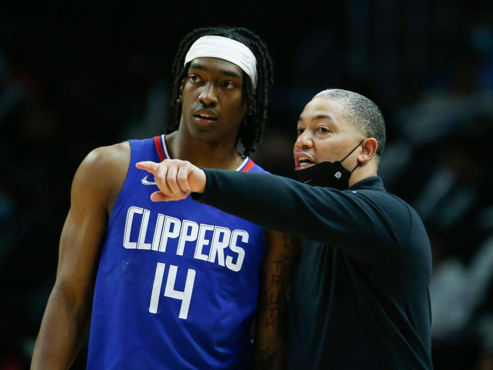 Tyronn Lue points while speaking to Terrence Mann during a Clippers game.