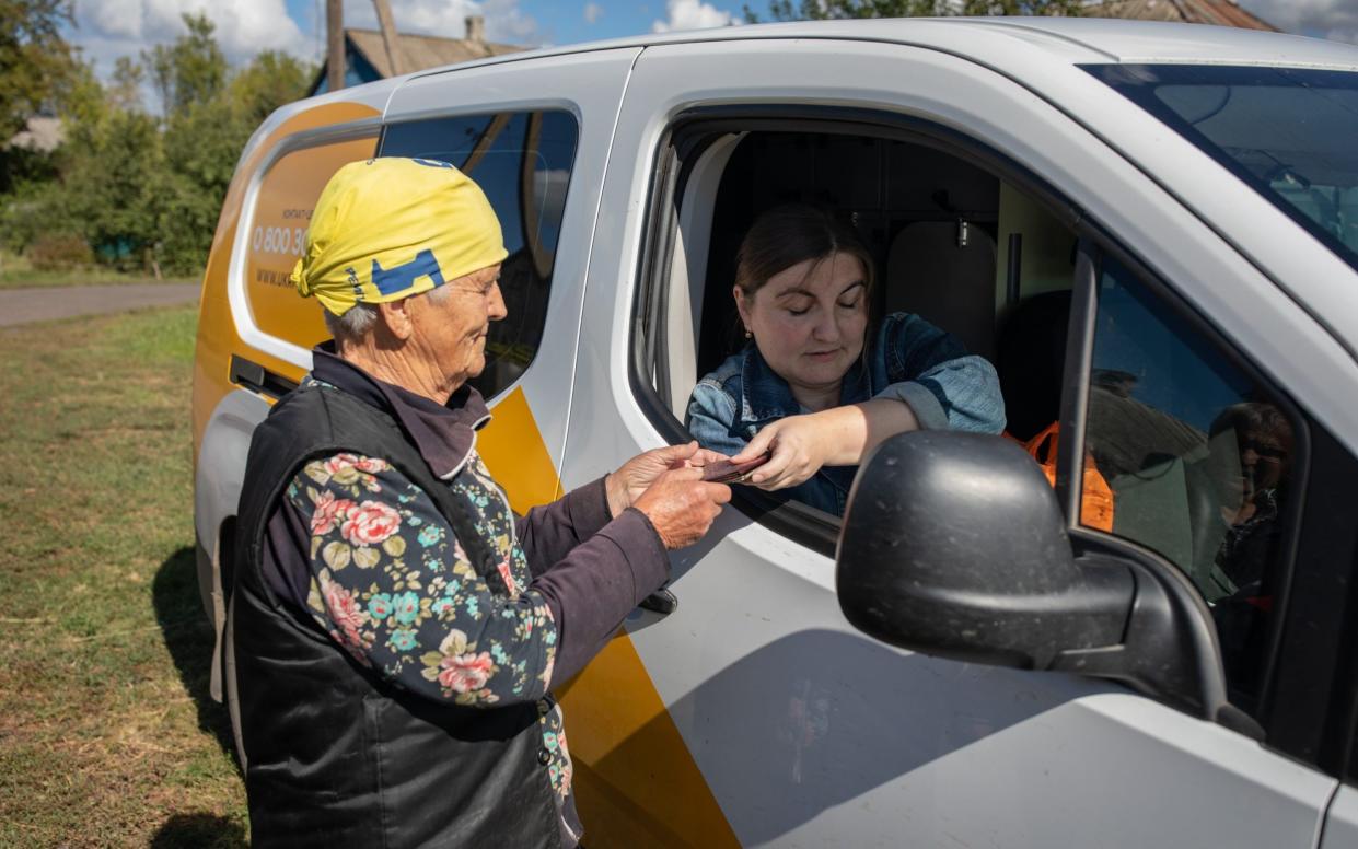 Olga Simonenka delivers Nina Shavchukâ's pension in a frontline village hear Bakhmut. Ukraine delivers state pensions in cash - Oliver Marsden