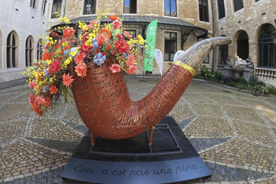 A giant pipe with flowers. in the interior yard of City Hall, Brussels, Belgium, Friday Aug. 11, 2023. The floral art was inspired by Belgian surrealist artist Rene Magritte’s “This is not a pipe”. Belgium has a century-old fling with surrealism and is always proud to flaunt it. This year they're combining it with an annual flower show in Brussels. (AP Photo/Mark Carlson)