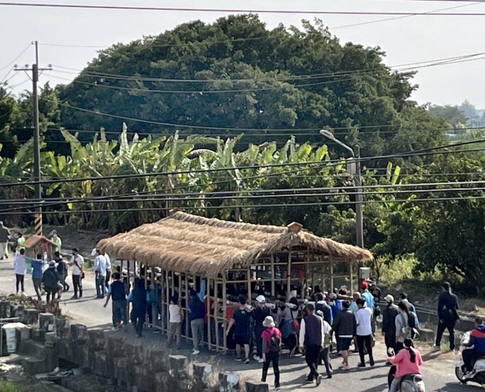 近百位民眾合力扛起竹籠茨，徒步走到溪南寮「舊茨地」。（記者陳治交攝）