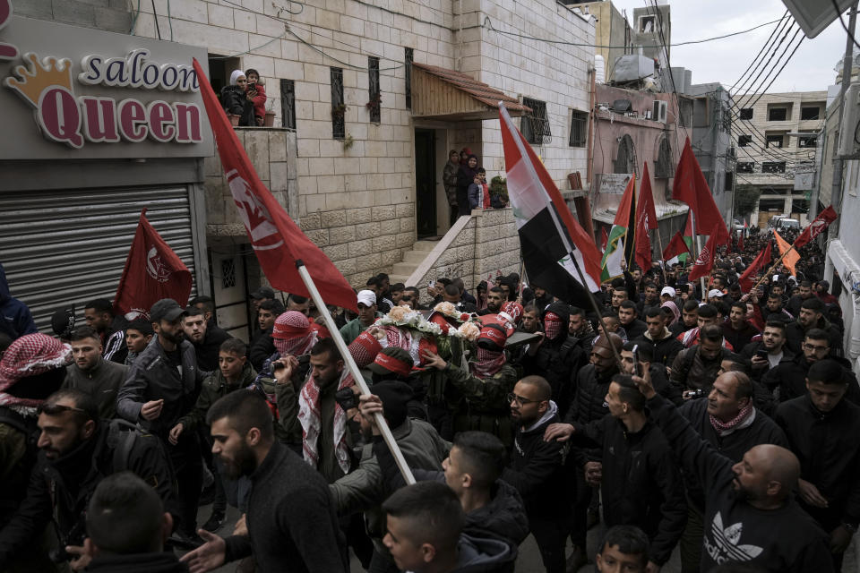 Mourners carry the body of 14-year-old Palestinian Omar Khumour during his funeral in the West Bank city of Bethlehem, Monday, Jan. 16, 2023. The Palestinian Health Ministry said Khumour died after being struck in the head by a bullet during an Israeli military raid into Dheisha refugee camp near the city of Bethlehem. The Israeli army said that forces entered the Dheisha camp and were bombarded by Molotov cocktails and rocks. It said soldiers responded to the onslaught with live fire. (AP Photo/Mahmoud Illean)