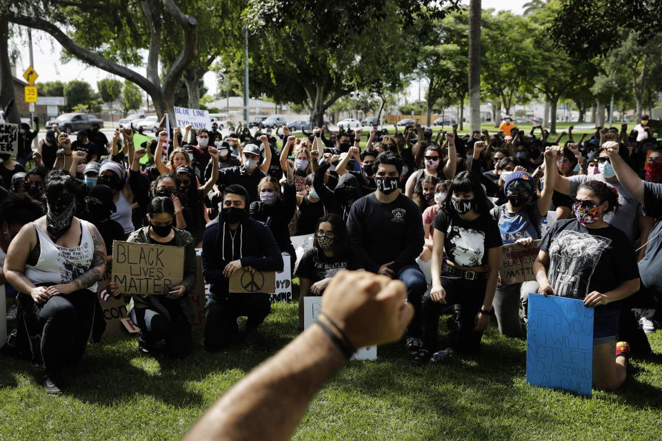 Demonstrators raise their fists Monday, June 1, 2020, during a protest over the death of George Floyd in Anaheim, Calif. (AP Photo/Jae C. Hong)