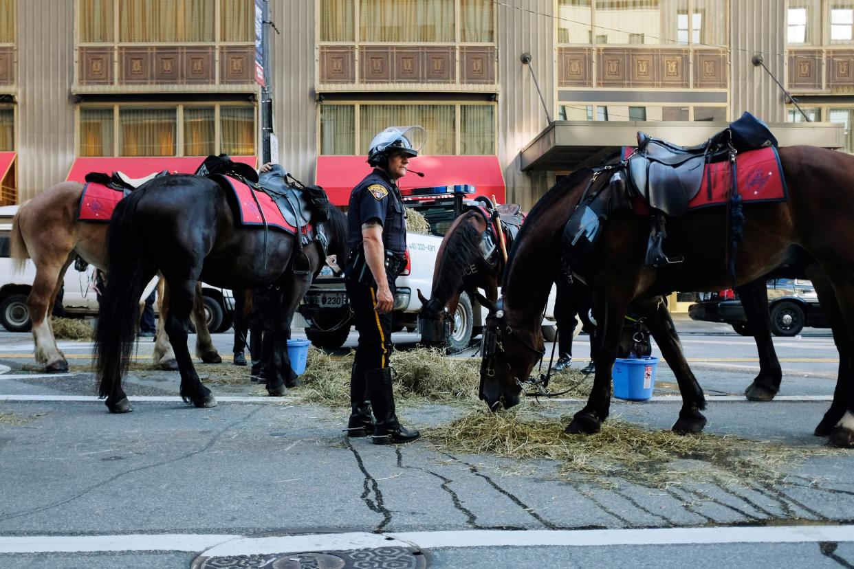 A Cleveland Police mounted officer feeds police horses on Ontario Street on July 20, 2016, in Cleveland, Ohio.  (AFP via Getty Images)