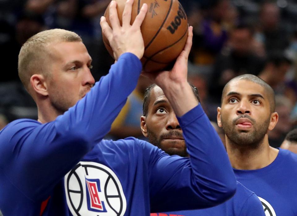 Clippers center Mason Plumlee, left, shoots in front of teammates Kawhi Leonard, center, and Nicolas Batum.