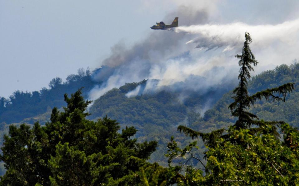 A Canadair firefighting aircraft battles forest fires on the edge of Mt Somma near the Mount Vesuvius volcano in Mount Vesuvius National Park, near Naples - Credit: CIRO FUSCO/ANSA