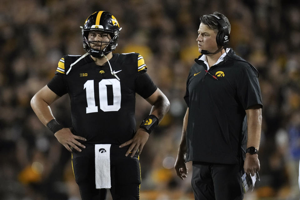 Iowa offensive coordinator Brian Ferentz talks with quarterback Deacon Hill (10) during the second half of an NCAA college football game against Michigan State, Saturday, Sept. 30, 2023, in Iowa City, Iowa. Iowa won 26-16. (AP Photo/Charlie Neibergall)