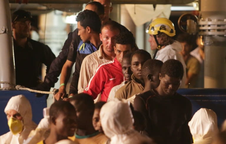 Migrants disembark from Swedish coast guard ship "Poseidon" in the port of Palermo on August 27, 2015 following a rescue operation in the Mediterranean Sea