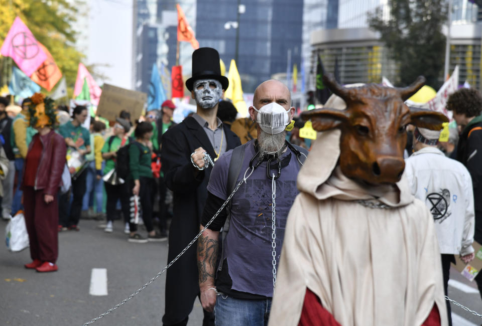 Protestors wear costumes as they participate in a climate march in Brussels, Sunday, Oct. 10, 2021. Some 80 organizations are joining in a climate march through Brussels to demand change and push politicians to effective action in Glasgow later this month.(AP Photo/Geert Vanden Wijngaert)