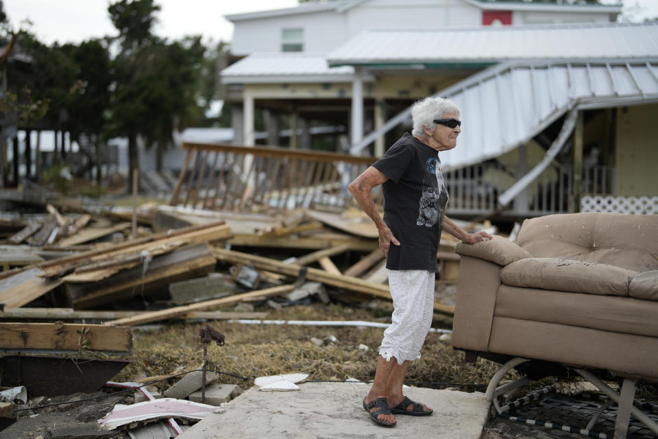 FILE - Tina Brotherton, 88, looks over the remains of her business, Tina's Dockside Inn, which was completely destroyed in Hurricane Idalia, as was Brotherton's nearby home, in Horseshoe Beach, Fla., Friday, Sept. 1, 2023, two days after the storm's passage. A resident of Horseshoe Beach since 1978, she lost her marina and the cafe next door in a 1993 disaster and had to replace the floors and beds at Tina's Dockside Inn. Now the hotel, which she has owned for 52 years, is destroyed in Idalia's wake. (AP Photo/Rebecca Blackwell, File)