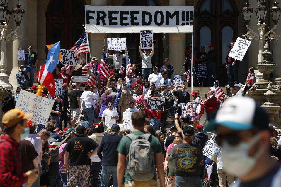 People protest at the State Capitol during a rally in Lansing, Mich., Wednesday, May 20, 2020. Barbers and hair stylists are protesting the state's stay-at-home orders, a defiant demonstration that reflects how salons have become a symbol for small businesses that are eager to reopen two months after the COVID-19 pandemic began. (AP Photo/Paul Sancya)