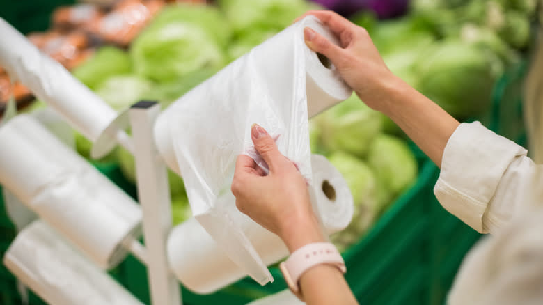 Person grabbing plastic bag