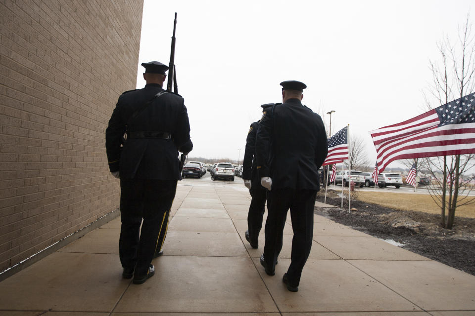 A color guard with members from New York, Elgin and North Aurora, Illinois, exit the building during a shift change before funeral services for slain McHenry County Sheriff's Deputy Jacob Keltner on Wednesday, March 13, 2019, at Woodstock North High School in Woodstock, Ill. Keltner was shot and killed while trying to serve an arrest warrant at a hotel on March 7, 2019. (Scott P. Yates/Rockford Register Star via AP)