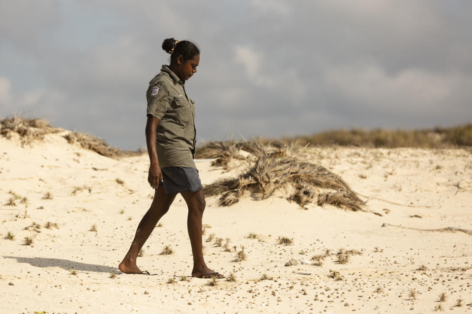 An Indigenous ranger walks along a remote sand dune in Northern Arnhem Land. 