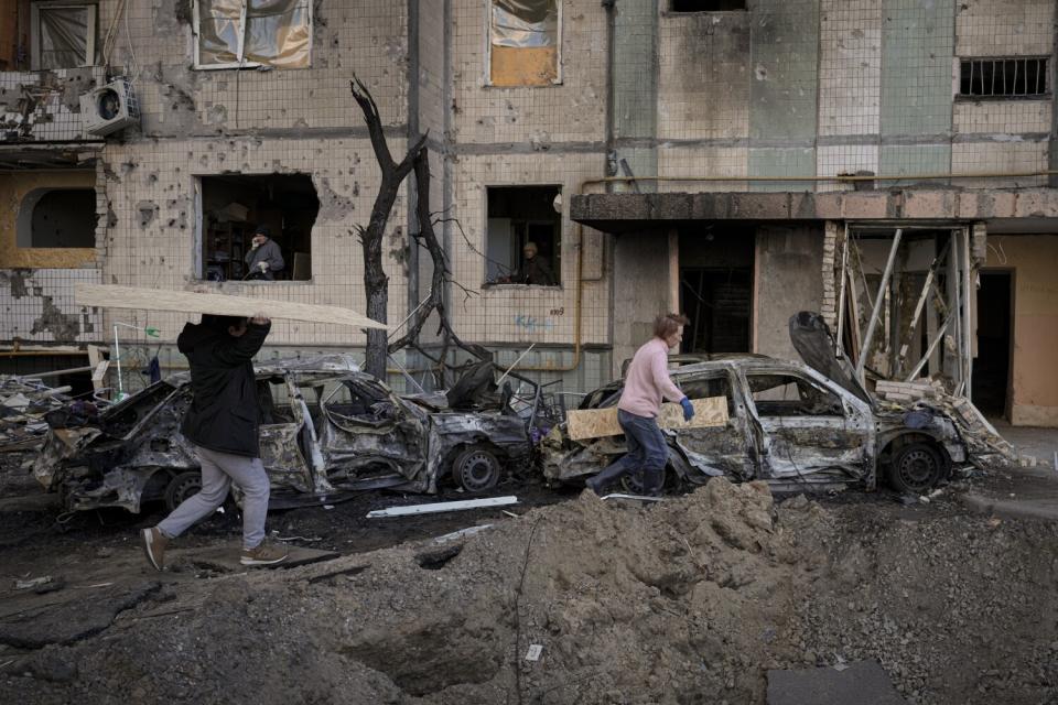 People walking by a damaged building