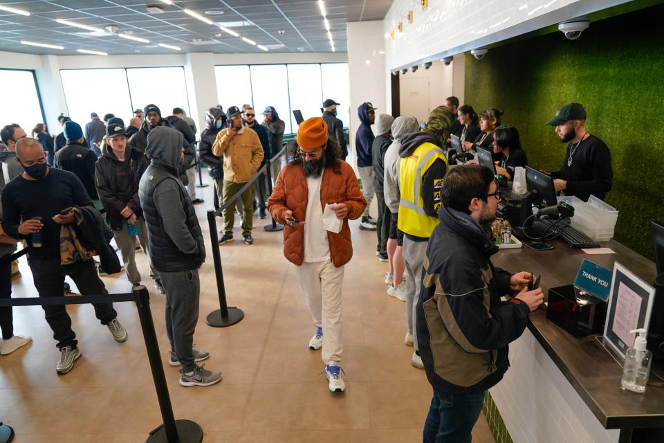 a crowd of people line up at a cannabis dispensary in new jersey