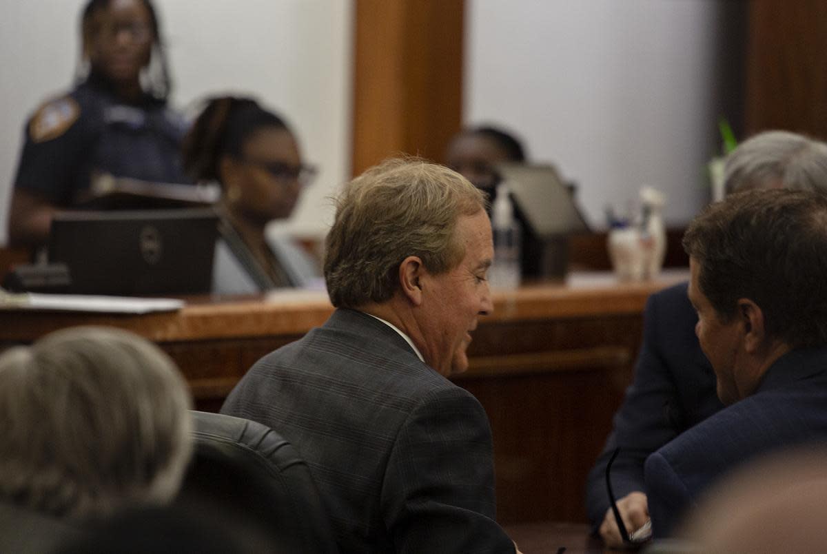 Texas Attorney General Ken Paxton talks with his team in the 185th Criminal District court at the Harris County Criminal Justice Center before his pretrial hearing March 26, 2024, in Houston.