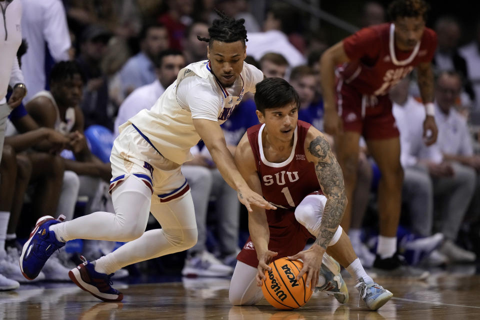 Kansas guard Bobby Pettiford Jr., left, tries to steal the ball from Southern Utah guard Felix Lemetti (1) during the first half of an NCAA college basketball game Friday, Nov. 18, 2022, in Lawrence, Kan. (AP Photo/Charlie Riedel)