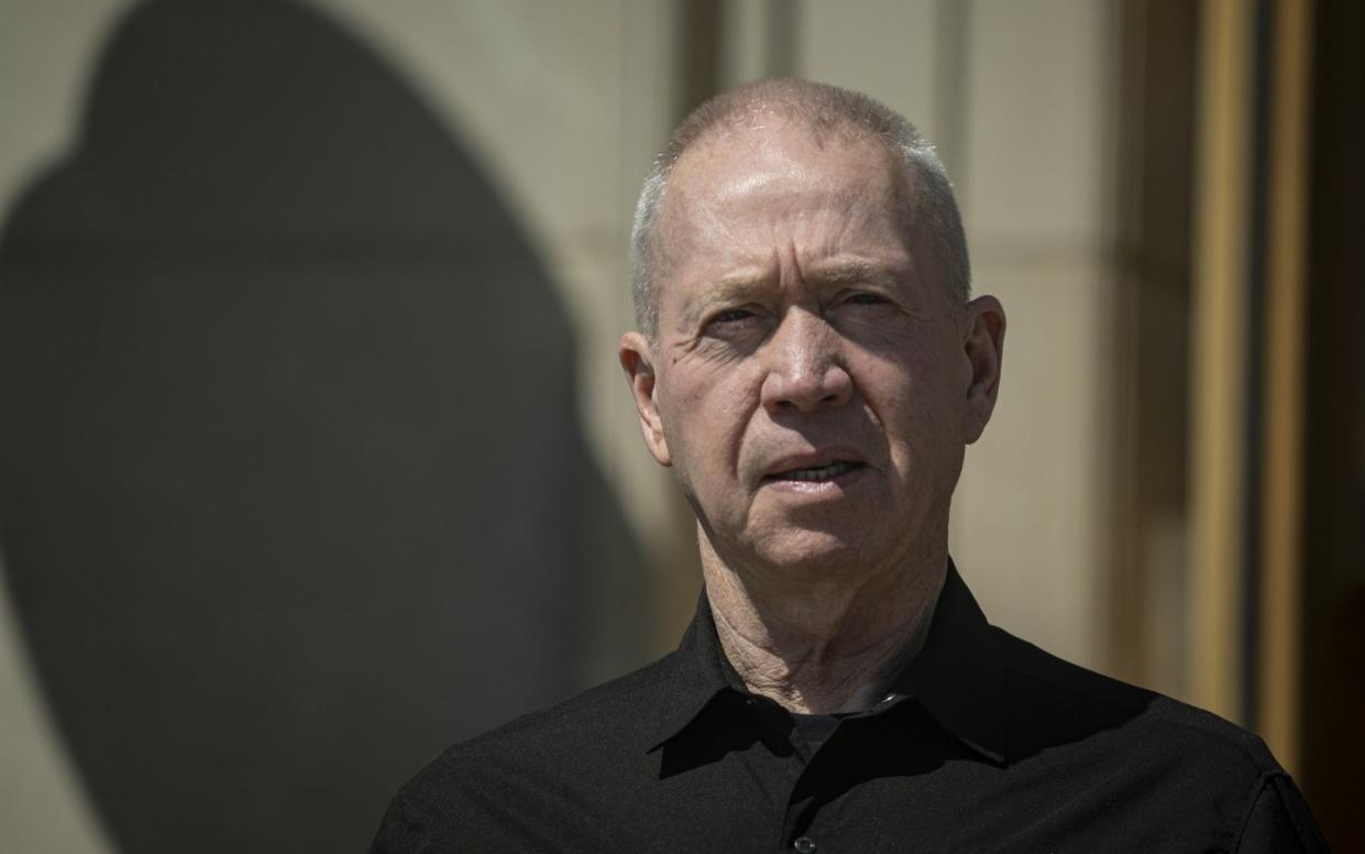 A picture of Yoav Gallant wearing a black shirt and standing outdoors in bright sunshine