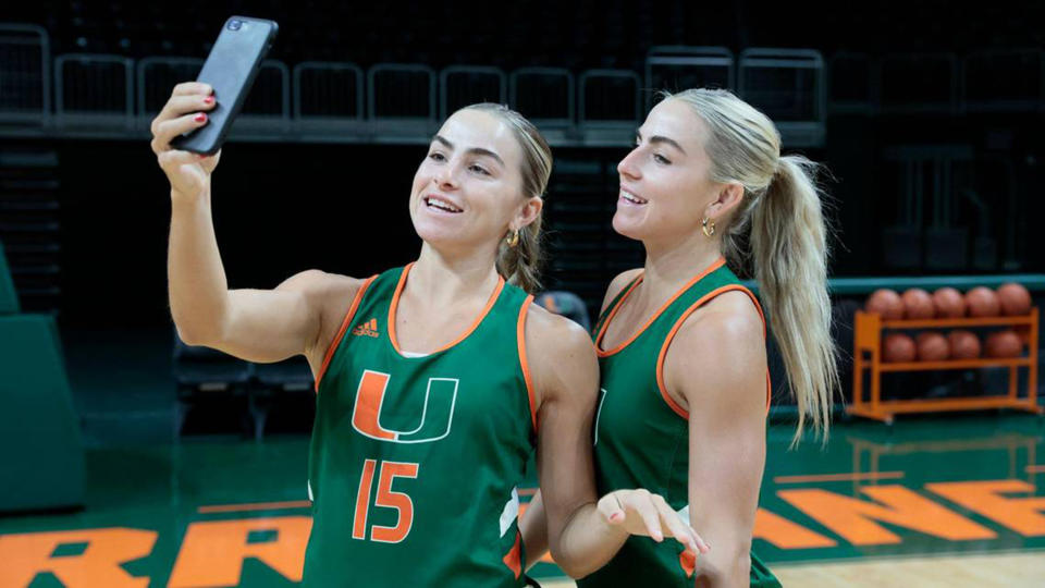 Miami Hurricanes women's basketball players Haley Cavinder (14) and Hanna Cavinder (15) have more than $1 million in endorsements and have been at the forefront of the college sports Name, Image, Likeness movement. They announced they will forego their final year of eligibility to pursue other career options. (Al Diaz/Miami Herald/Tribune News Service via Getty Images)