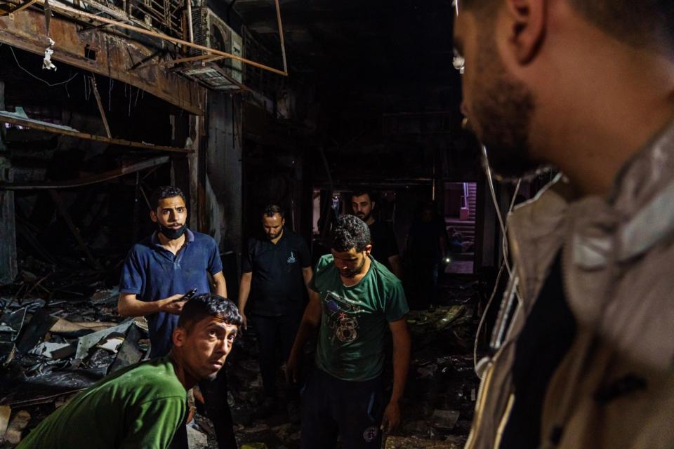 Shopkeepers try to salvage what they can from their damaged stores.