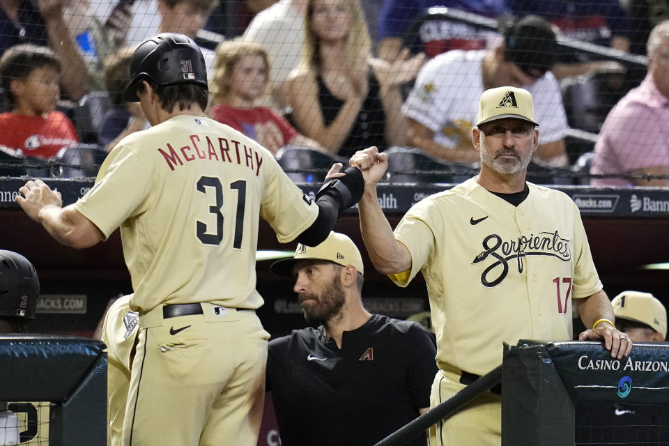 Arizona Diamondbacks' Jake McCarthy (31) celebrates his run scored against the Cleveland Guardians with manager Torey Lovullo (17) during the second inning of a baseball game Friday, June 16, 2023, in Phoenix. (AP Photo/Ross D. Franklin)