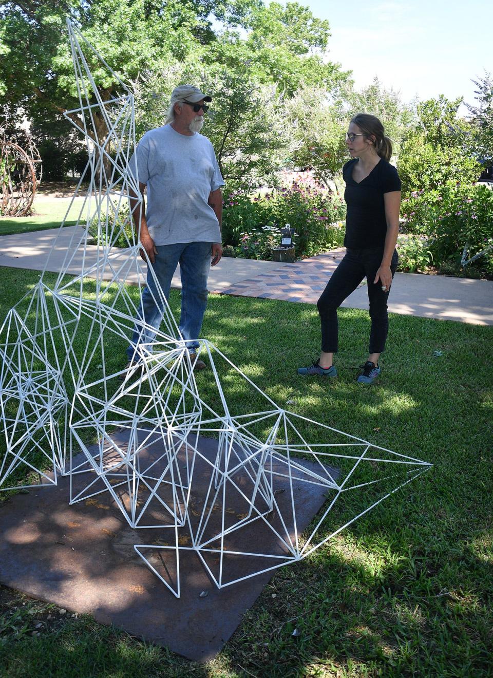 In this 2021 photo, sculpture artist and installer Joe Barrington talks with artist Amy Hoagland about her powder coated welded steel piece, "Ice Frame", at the Kemp Center for the Arts.