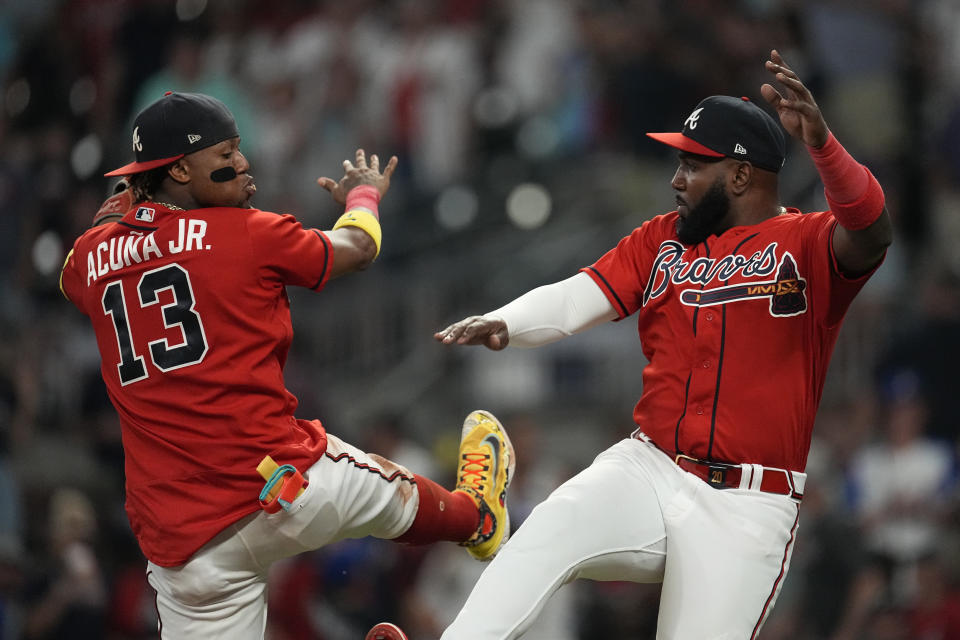 Atlanta Braves right fielder Ronald Acuna Jr. (13) and designated hitter Marcell Ozuna (20) celebrate after defeating the Colorado Rockies in a baseball game, Friday, June 16, 2023, in Atlanta. (AP Photo/John Bazemore)