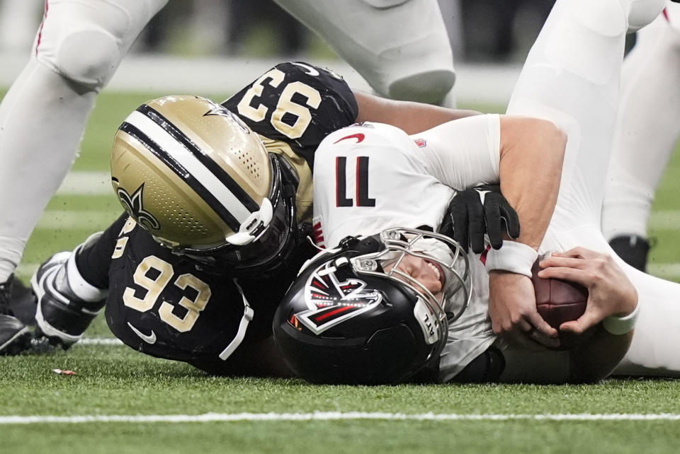 Atlanta Falcons quarterback Logan Woodside (11) is sacked by New Orleans Saints defensive tackle Nathan Shepherd (93) in the second half of an NFL football game in New Orleans, Sunday, Jan. 7, 2024. (AP Photo/Gerald Herbert)