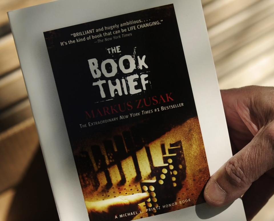 A man hands out free copies of The Book Thief as part of World Book Night