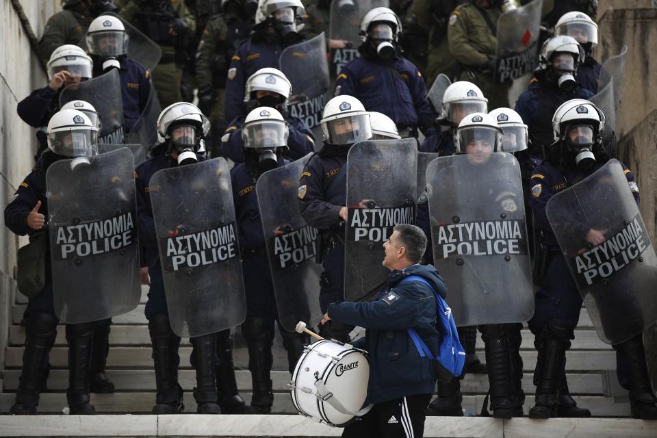 A protester shouts at riot police during a rally outside the Greek Parliament in Athens, Friday, Jan. 11, 2019. About 1,500 people took part in the protest. Teachers' unions oppose the government's selection process for the planned hiring of 15,000 new teachers over the next three years. (AP Photo/Thanassis Stavrakis)