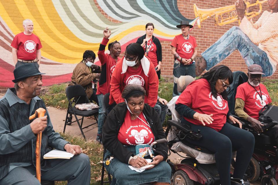 MTU member Joyce Warren (raising hand) chants along with other members at a press conference they held in November to call attention to the notices they were getting from Millenia Co.