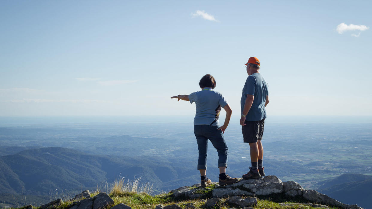 Senior Couple Admiring the View from the Top of the Mountain.