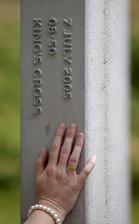 A woman places her hand on the 7 July Memorial monument in Hyde Park, as she pays her respects, to those who lost their lives in the 7/7 attack in 2005, in London, Britain, July 6, 2015. REUTERS/Peter Nicholls